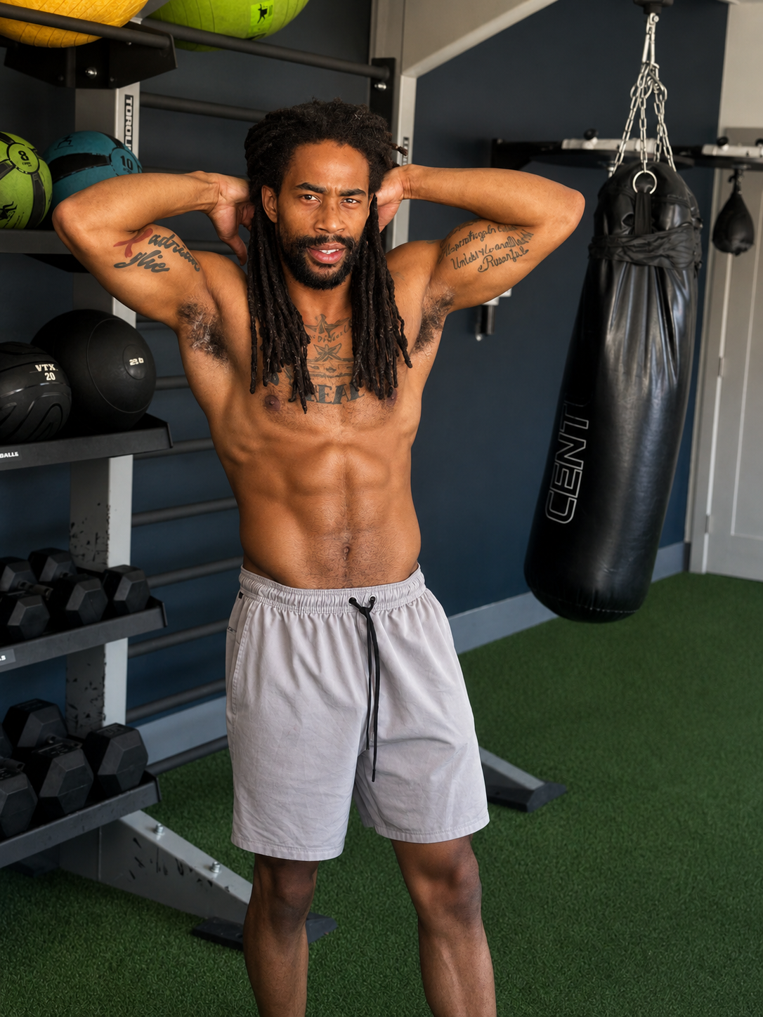 Functional fitness coach in a home gym with medicine balls, dumbbells and a heavy bag